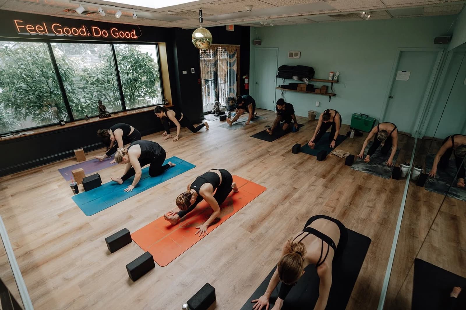 A Revel Yoga class practicing in the studio beneath the words Feel Good Do Good